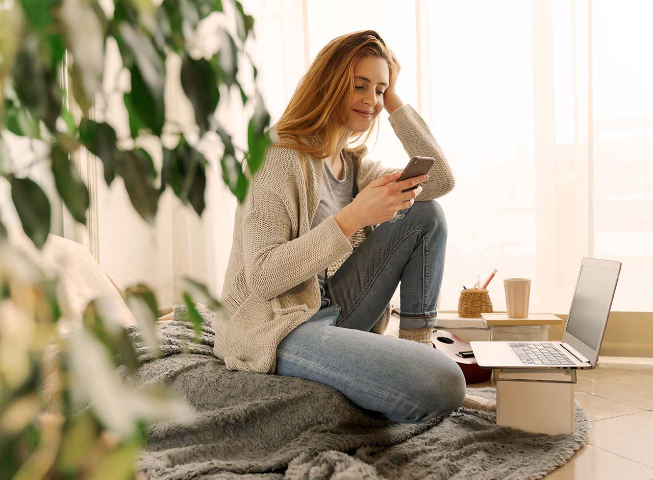 Kvinde søger bolig online hjemme i stuen